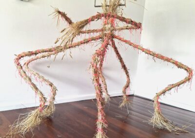 Spider-like sculpture in stainless steel, resin & covered in hay